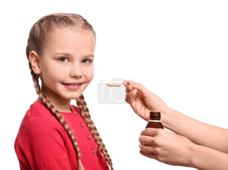 Téléchargez les photos : Mother giving syrup to her daughter from dosing spoon against white background - en image libre de droit