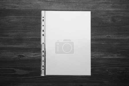 Foto de Punched pocket with paper sheet on black wooden table, top view - Imagen libre de derechos