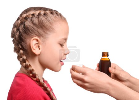 Téléchargez les photos : Mother giving syrup to daughter from measuring cup against white background - en image libre de droit