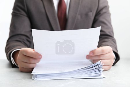 Photo for Man reading document at table in office, closeup - Royalty Free Image