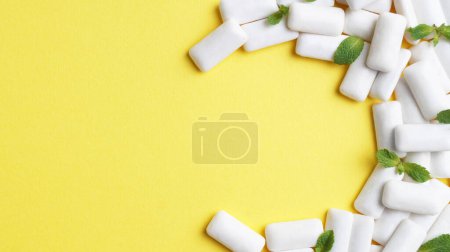 Photo for Tasty chewing gums and mint leaves on yellow background, flat lay. Space for text - Royalty Free Image