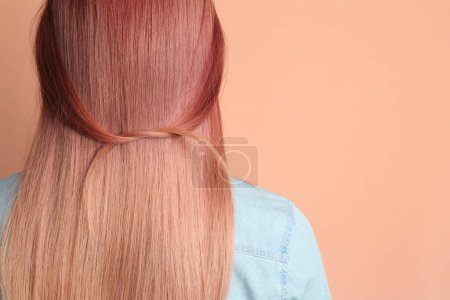 Foto de Woman with bright dyed hair on pale pink background, back view. Space for text - Imagen libre de derechos