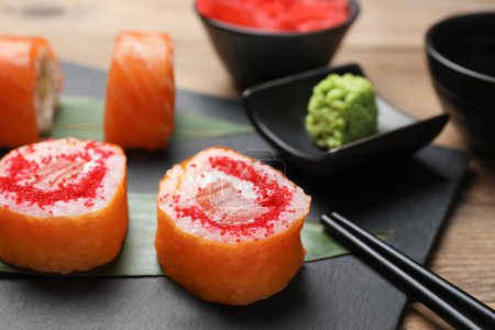 Foto de Delicious sushi rolls with tobiko on wooden table, closeup - Imagen libre de derechos