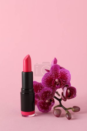 Photo for Beautiful lipstick and orchid flowers on pink background - Royalty Free Image