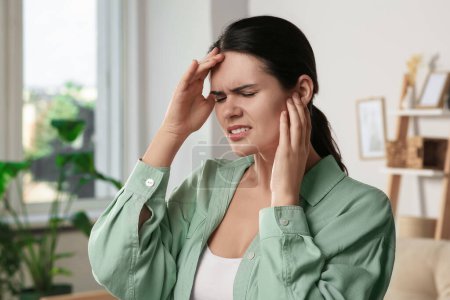 Photo for Young woman suffering from ear pain at home - Royalty Free Image