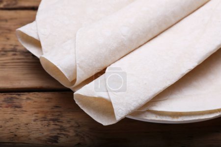 Photo for Delicious rolled Armenian lavash on wooden table, closeup - Royalty Free Image