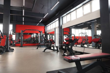 Photo for Spacious gym with professional equipment and mirrors - Royalty Free Image