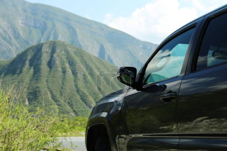 Téléchargez les photos : Black car near beautiful mountains and plants outdoors - en image libre de droit
