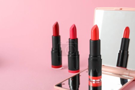 Photo for Different beautiful lipsticks and mirror on pink background, space for text - Royalty Free Image