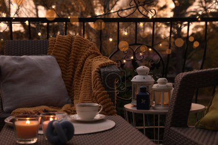 Photo for Beautiful view of garden furniture with pillow, soft blanket and burning candles at balcony - Royalty Free Image