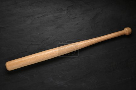 Foto de Baseball bat on black background, top view. Sports equipment - Imagen libre de derechos