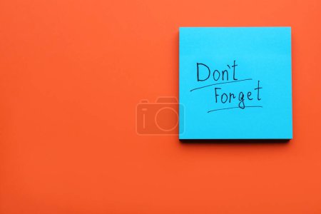 Photo for Paper note with phrase Don t Forget on orange background, top view. Space for text - Royalty Free Image