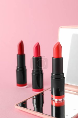 Photo for Different beautiful lipsticks and mirror on pink background - Royalty Free Image