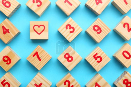 Photo for Wooden cubes with numbers and heart on light blue background, flat lay - Royalty Free Image
