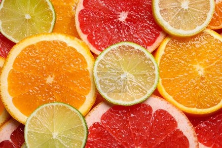 Photo for Slices of different citrus fruits as background, top view - Royalty Free Image
