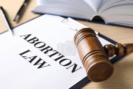 Foto de Clipboard with text Abortion Law and gavel on wooden table, closeup - Imagen libre de derechos