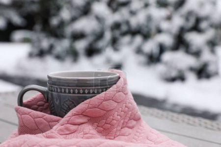 Foto de Winter morning. Cup with hot drink wrapped in pink sweater outdoors, closeup. Space for text - Imagen libre de derechos