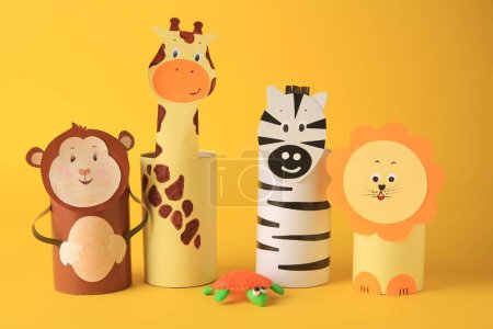 Téléchargez les photos : Toy monkey, giraffe, lion and zebra made from toilet paper hubs on yellow background. Children's handmade ideas - en image libre de droit
