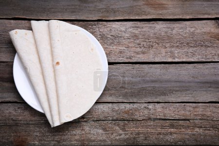 Photo for Delicious folded Armenian lavash on wooden table, top view. Space for text - Royalty Free Image