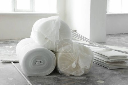 Photo for Polyethylene foam rolls on floor near windows in room - Royalty Free Image
