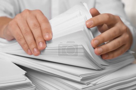 Photo for Man stacking documents in office, closeup view - Royalty Free Image