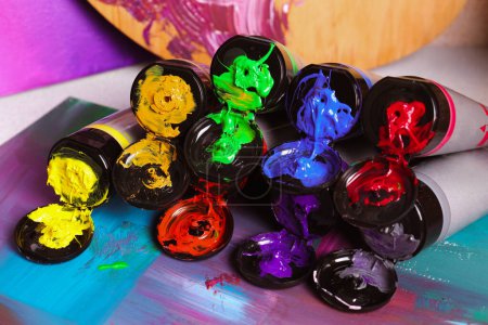 Foto de Tubes of colorful paints and canvas on table, closeup - Imagen libre de derechos