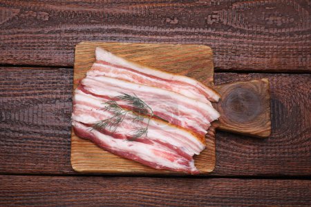 Photo for Slices of tasty pork fatback with dill on wooden table, top view - Royalty Free Image