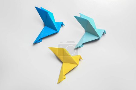 Foto de Hermosas aves de origami de colores sobre fondo blanco, plano - Imagen libre de derechos