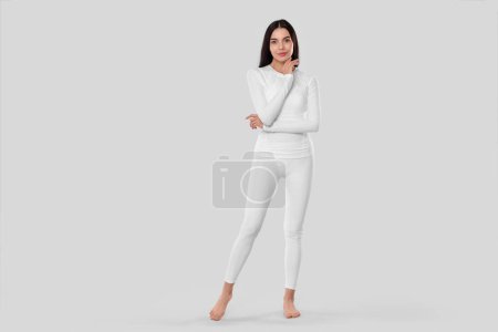 Téléchargez les photos : Woman in warm thermal underwear on light background. Space for text - en image libre de droit