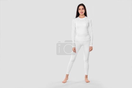 Téléchargez les photos : Woman in warm thermal underwear on light background. Space for text - en image libre de droit