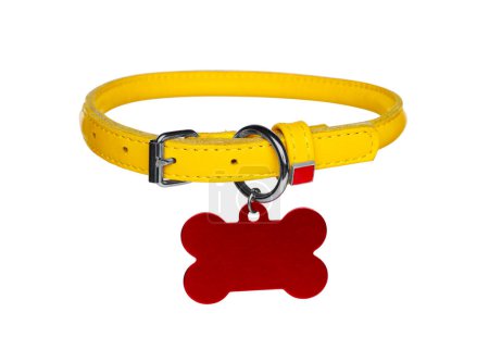 Foto de Collar de perro de cuero amarillo con etiqueta en forma de hueso aislado en blanco - Imagen libre de derechos