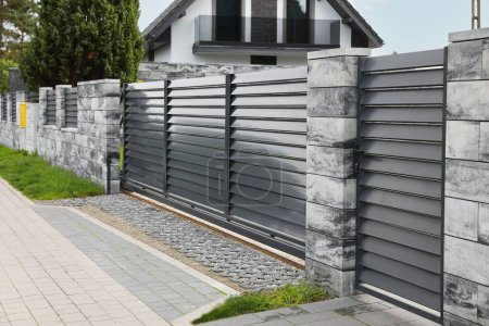 Metal gates near marble columns and house outdoors