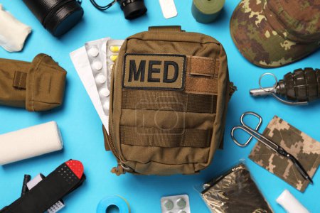 Téléchargez les photos : Military first aid kit and equipment on light blue background, flat lay - en image libre de droit