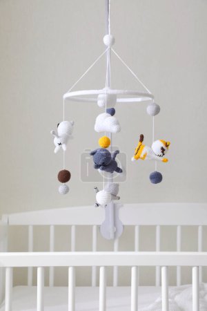 Photo for Modern crib with baby mobile in children's room. Interior design - Royalty Free Image