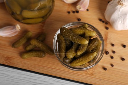 Foto de Tasty pickled cucumbers in glass bowl on wooden table, above view - Imagen libre de derechos