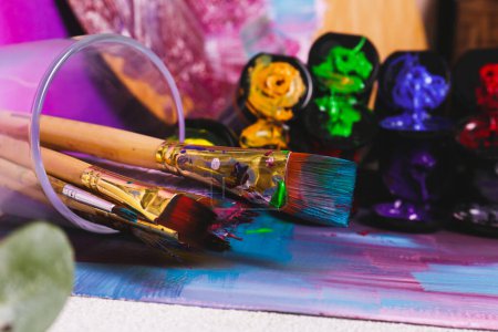 Foto de Brushes with colorful paints and canvas, closeup - Imagen libre de derechos