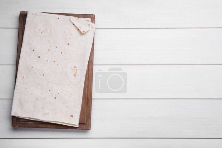 Photo for Delicious Armenian lavash on white wooden table, top view. Space for text - Royalty Free Image