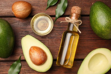 Photo for Cooking oil and fresh avocados on wooden table, flat lay - Royalty Free Image