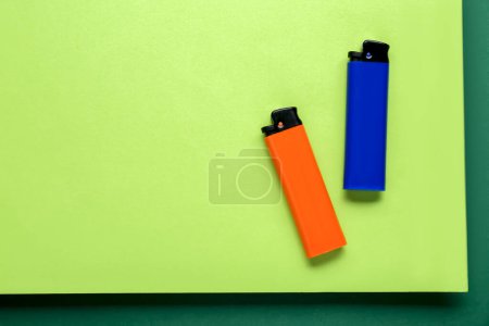 Téléchargez les photos : Stylish small pocket lighters on color background, flat lay. Space for text - en image libre de droit