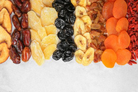 Foto de Diferentes frutas secas sabrosas sobre papel, planas - Imagen libre de derechos