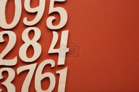 Photo for Wooden numbers on brown background, flat lay with space for text - Royalty Free Image