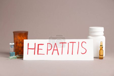 Téléchargez les photos : Word Hepatitis, vials and bottles of pills on beige background - en image libre de droit