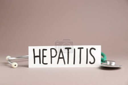 Téléchargez les photos : Word Hepatitis and stethoscope on beige background - en image libre de droit