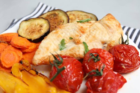 Delicious cooked chicken and vegetables on plate, closeup. Healthy meals from air fryer