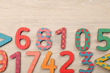 Photo for Colorful numbers and mathematical symbols on light wooden table, flat lay. Space for text - Royalty Free Image
