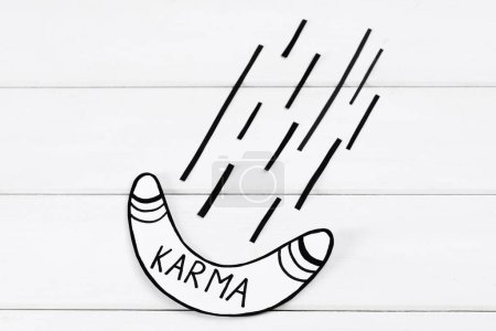 Téléchargez les photos : Paper boomerang with word Karma on white wooden table, flat lay - en image libre de droit