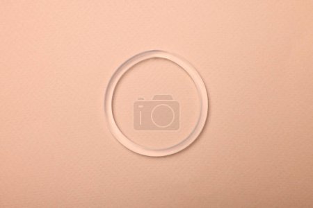 Téléchargez les photos : Diaphragm vaginal contraceptive ring on beige background, top view - en image libre de droit