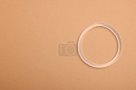 Téléchargez les photos : Diaphragm vaginal contraceptive ring on beige background, top view. Space for text - en image libre de droit
