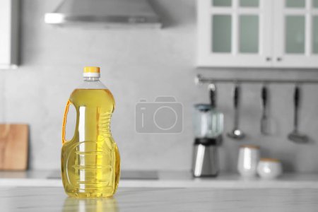 Photo for Bottle of cooking oil on white marble table in kitchen. Space for text - Royalty Free Image