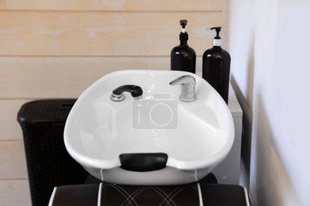 Téléchargez les photos : Modern wash unit with professional care products in barbershop - en image libre de droit